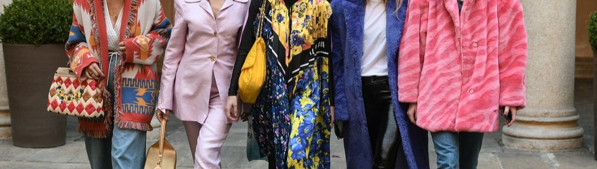 grupe moteru apsirengusiu spalvingais drabuziais ir aksesuarais mieste