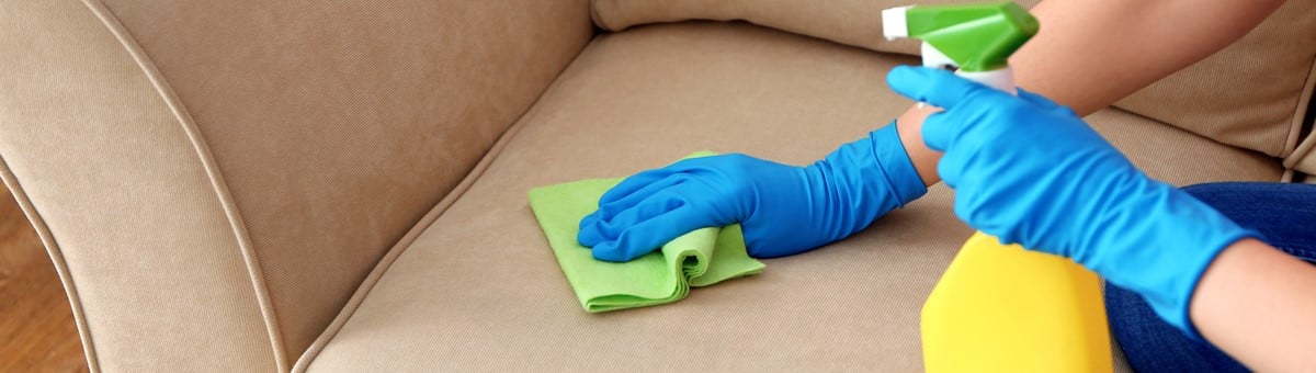 женщина чистит свой тканевый диван-кровать