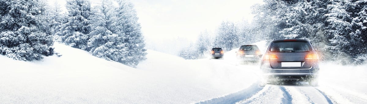automobiliai ziema vaziuoja apsnigtu keliu