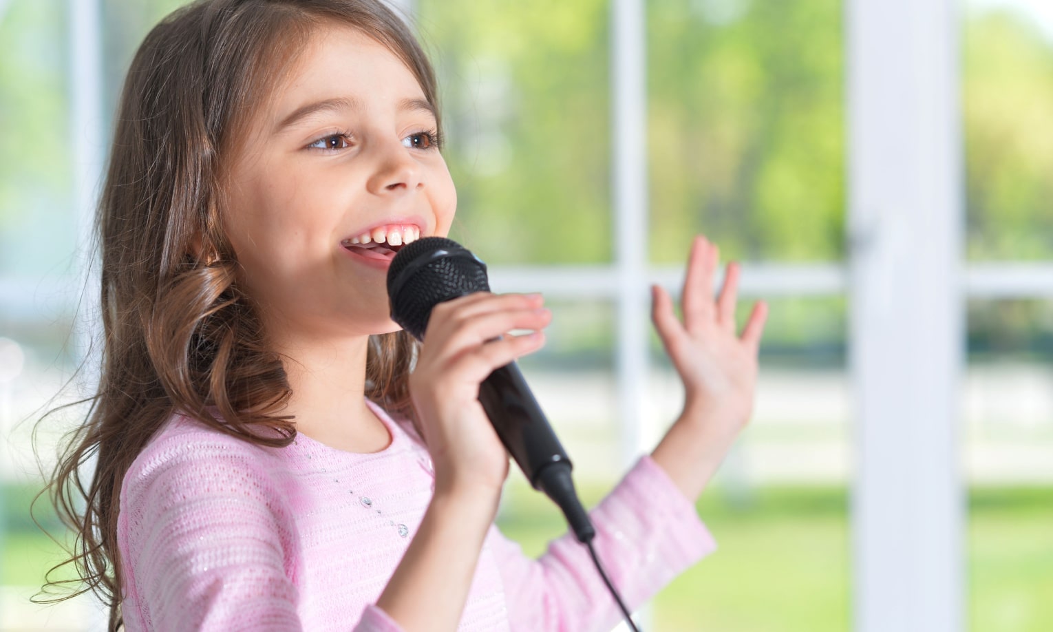 mergaite dainuoja su mikrofonu